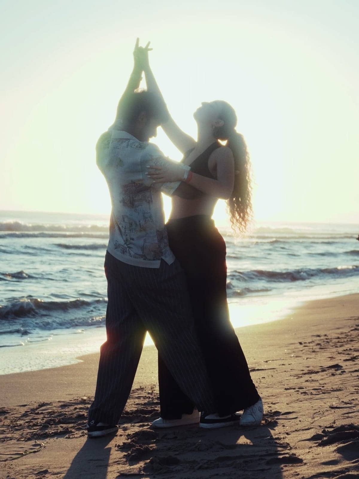 A couple dancing on the beach at sunset